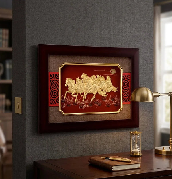 Decorative wall art with horses in a wooden frame on a gray wall above a desk.