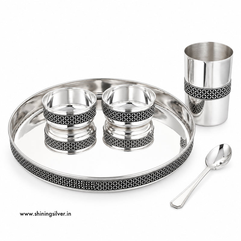 Shining Silver, A silver-toned stainless steel tea or coffee cup set on a white background, including a large oval tray, a tall cup, two small bowls, and a spoon. The pieces feature black geometric filigree detailing around the rims.