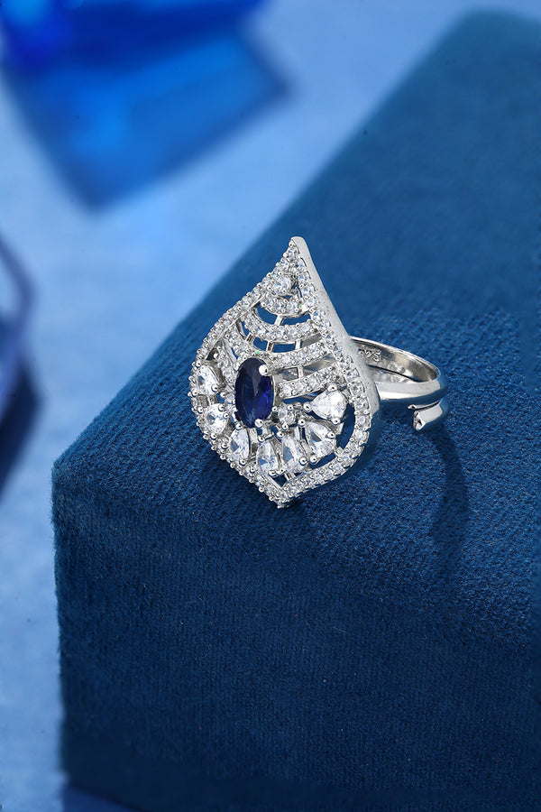Cocktail design 925 Sterling Silver Ring For Women studded with American diamonds and sapphires placed on a blue display base