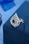 Cocktail design 925 Sterling Silver Ring For Women studded with American diamonds and sapphires placed on a blue display base