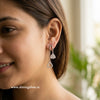 Close-up of a woman wearing silver earrings with a blurred background “shiningsilver”