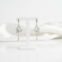 Butterfly-shaped earrings with pearl drops on a white background “shiningsilver.in”