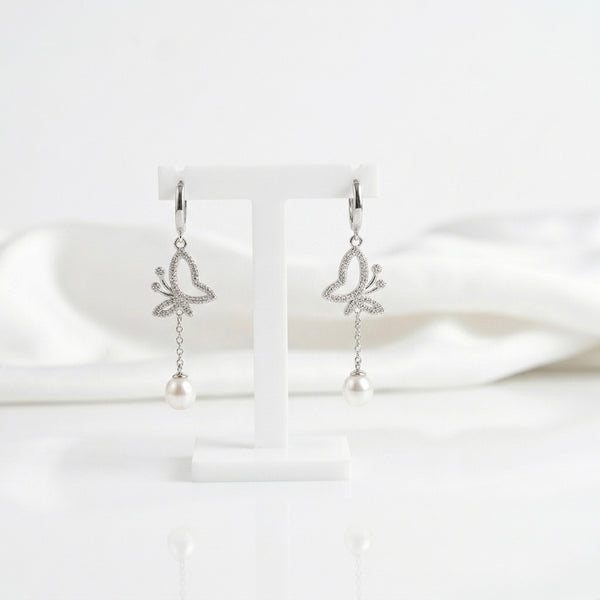Butterfly-shaped earrings with pearl drops on a white background “shiningsilver.in”