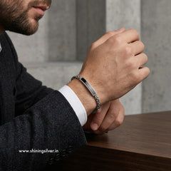 Man wearing a silver bracelet on his wrist with a blurred background