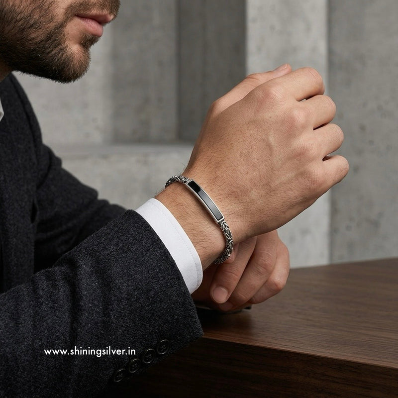 Man wearing a silver bracelet on his wrist with a blurred background