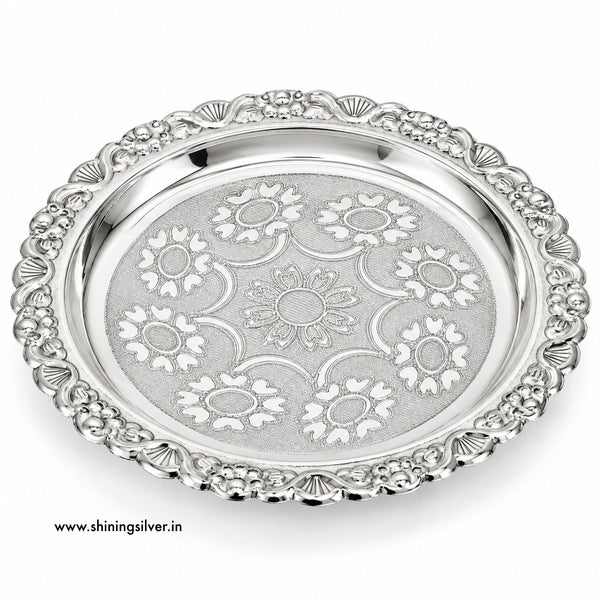 An ornate silver serving platter with a decorative floral pattern engraved on the center and a matching beaded border, shown on a white background with a website watermark.