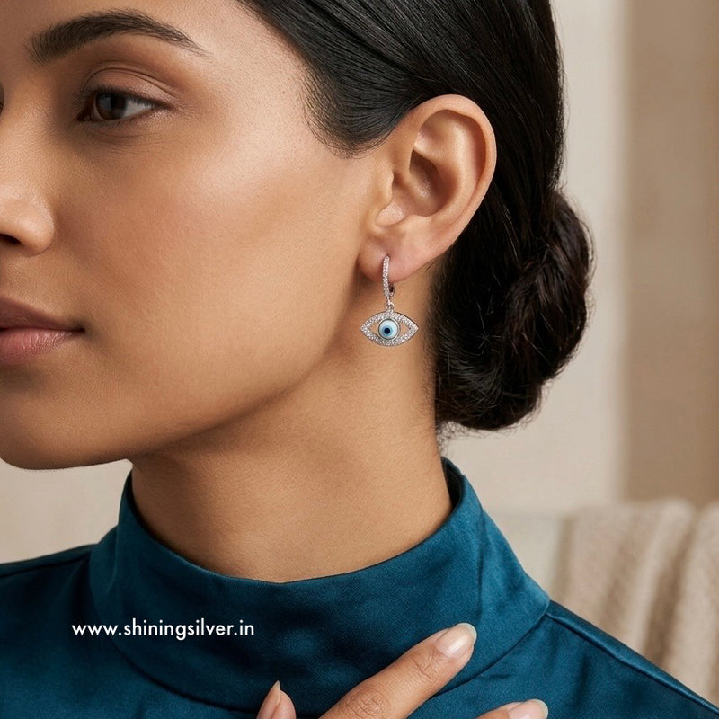 Woman wearing an evileye-shaped earring with a blurred background