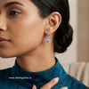Woman wearing an evileye-shaped earring with a blurred background