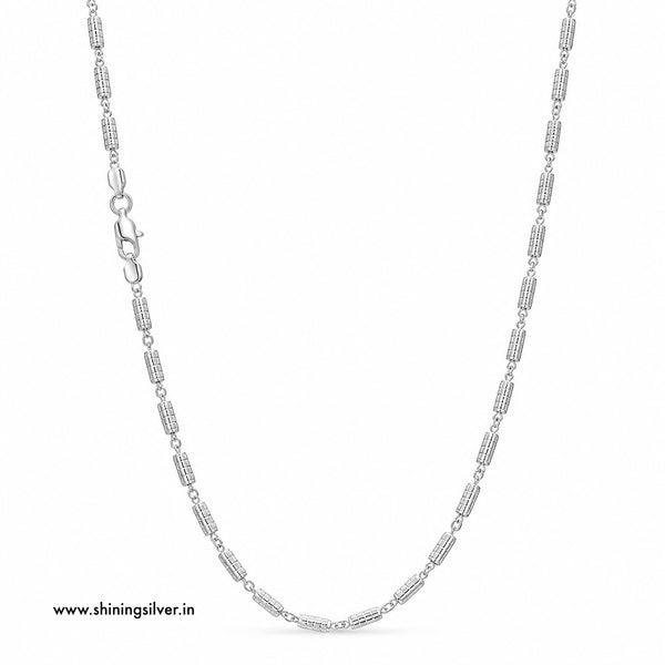 A silver-toned chain necklace with cylindrical links, displayed on a clean white background. A small website watermark 'www.