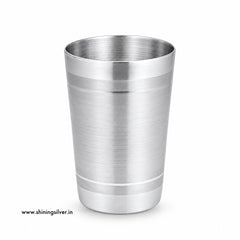 A brushed stainless steel cocktail shaker tumbler with a polished rim and base, shown on a clean white background with a small website watermark in the lower-left corner. Shining Silver