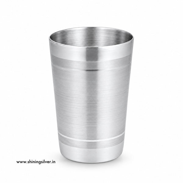 A brushed stainless steel cocktail shaker tumbler with a polished rim and base, shown on a clean white background with a small website watermark in the lower-left corner. Shining Silver