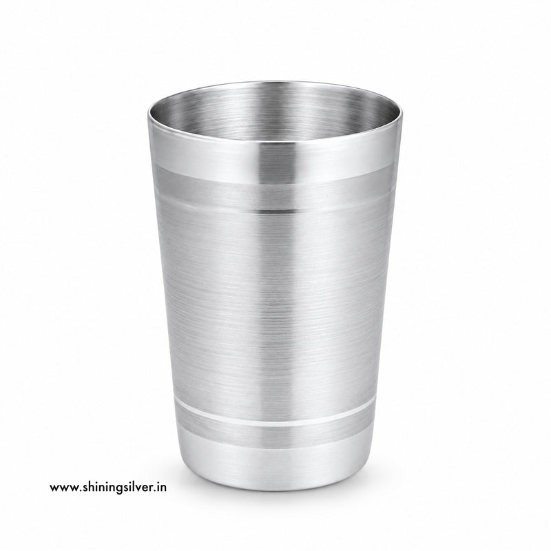 A brushed stainless steel cocktail shaker tumbler with a polished rim and base, shown on a clean white background with a small website watermark in the lower-left corner. Shining Silver