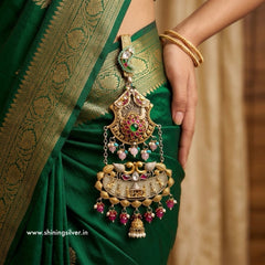 Green saree with gold jewelry held by a hand, brand 'Shining Silver' visible