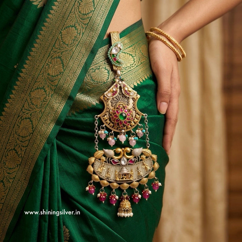 Green saree with gold jewelry held by a hand, brand 'Shining Silver' visible