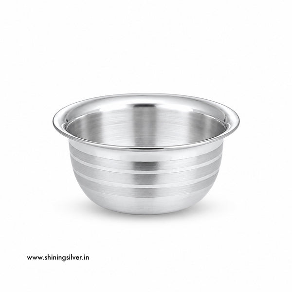 A stainless steel mixing bowl with a brushed metallic finish and horizontal ridges on the exterior, shown on a plain white background with a small website watermark in the lower left corner.