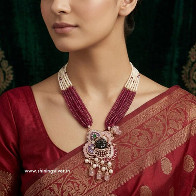 Woman wearing a maroon saree with a shrinath ji detailed necklace, brand 'Shining Silver' visible.