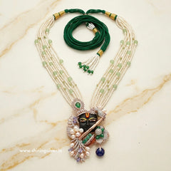 Rosegold plated Silver shrinath ji necklace with green and white beads on a marble surface