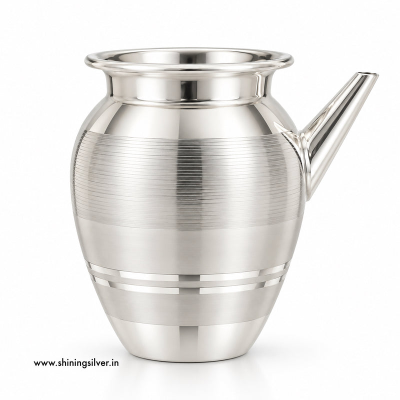 A polished silver-toned metal pitcher with a flared rim, a short angled spout, and horizontal brushed bands on the body, shown on a clean white background.