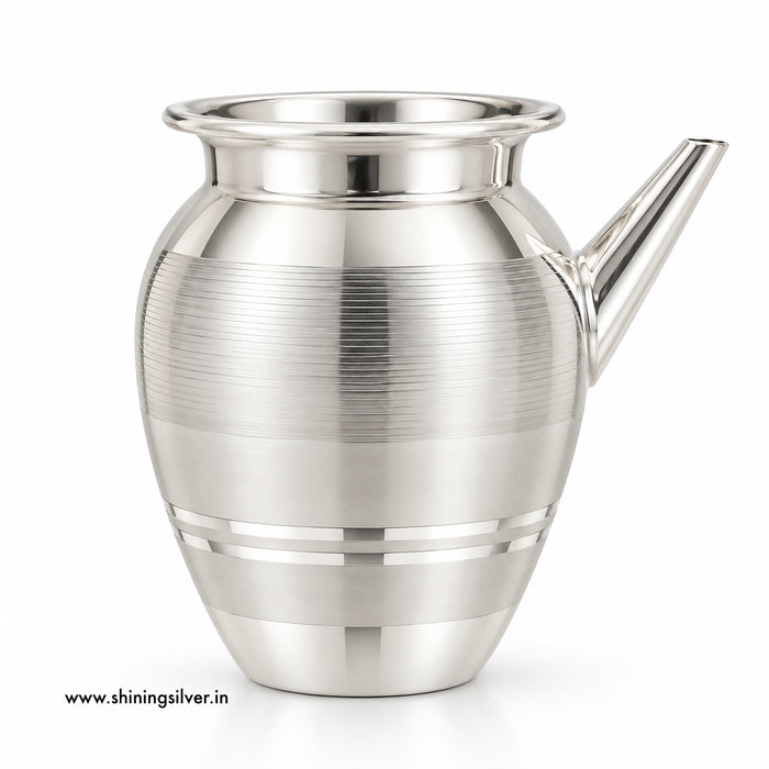 A polished silver-toned metal pitcher with a flared rim, a short angled spout, and horizontal brushed bands on the body, shown on a clean white background.
